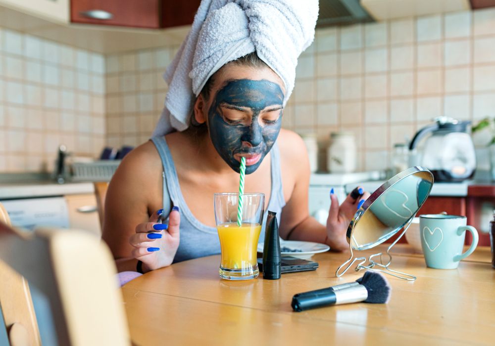 Frau mit Gesichtsmaske trinkt einen Orangensaft