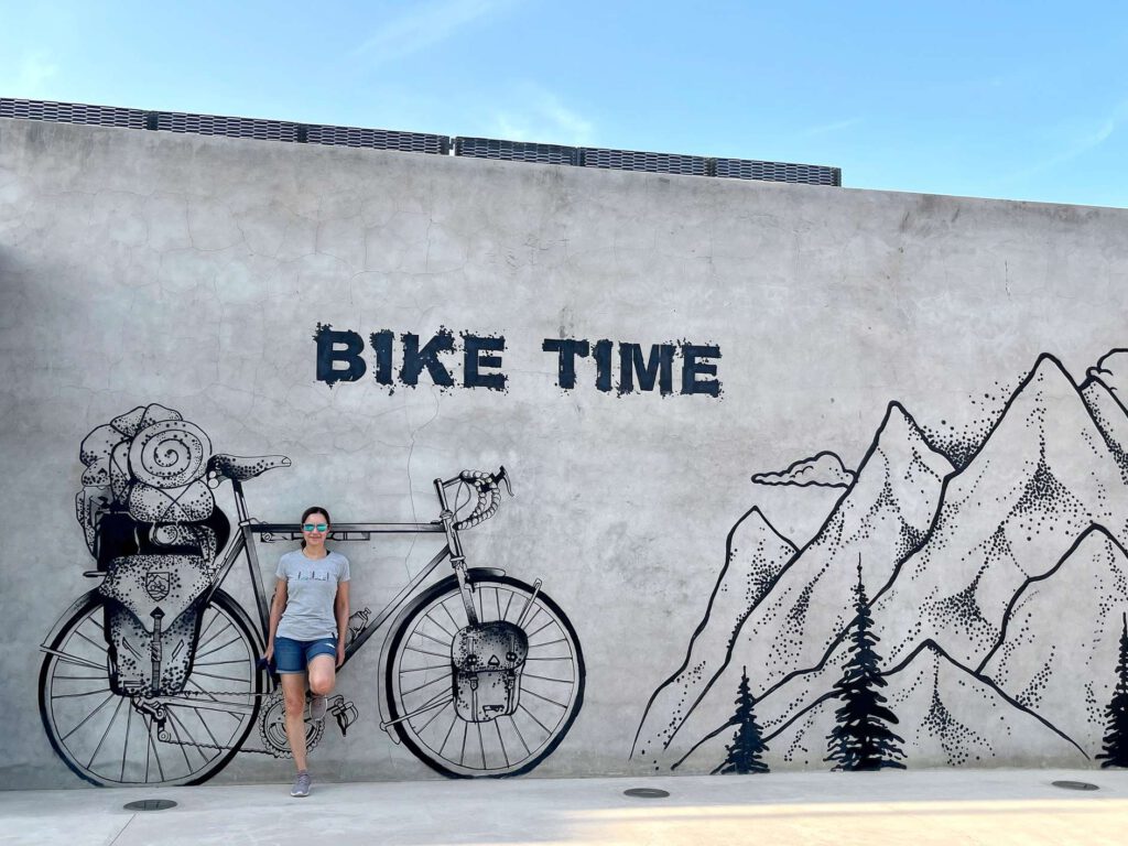 Ein Wandbild mit der Aufschrift "Bike Time" und einer Illustration eines Fahrrads und Bergen im Hintergrund.