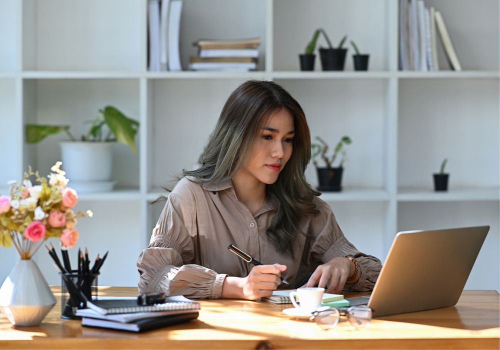 Frau arbeitet im Büro und fokussiert sich auf dem Bildschirm