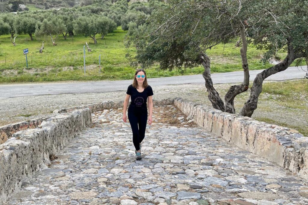 Woman walking along a wide path with cobblestones
